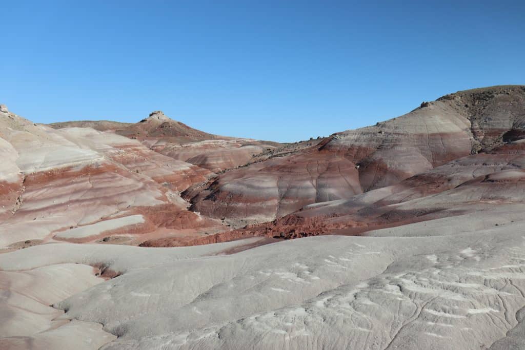 Layered red and gray badlands formations in Capitol Reef National Park, Utah, showing colorful desert hills and eroded sandstone ridges.