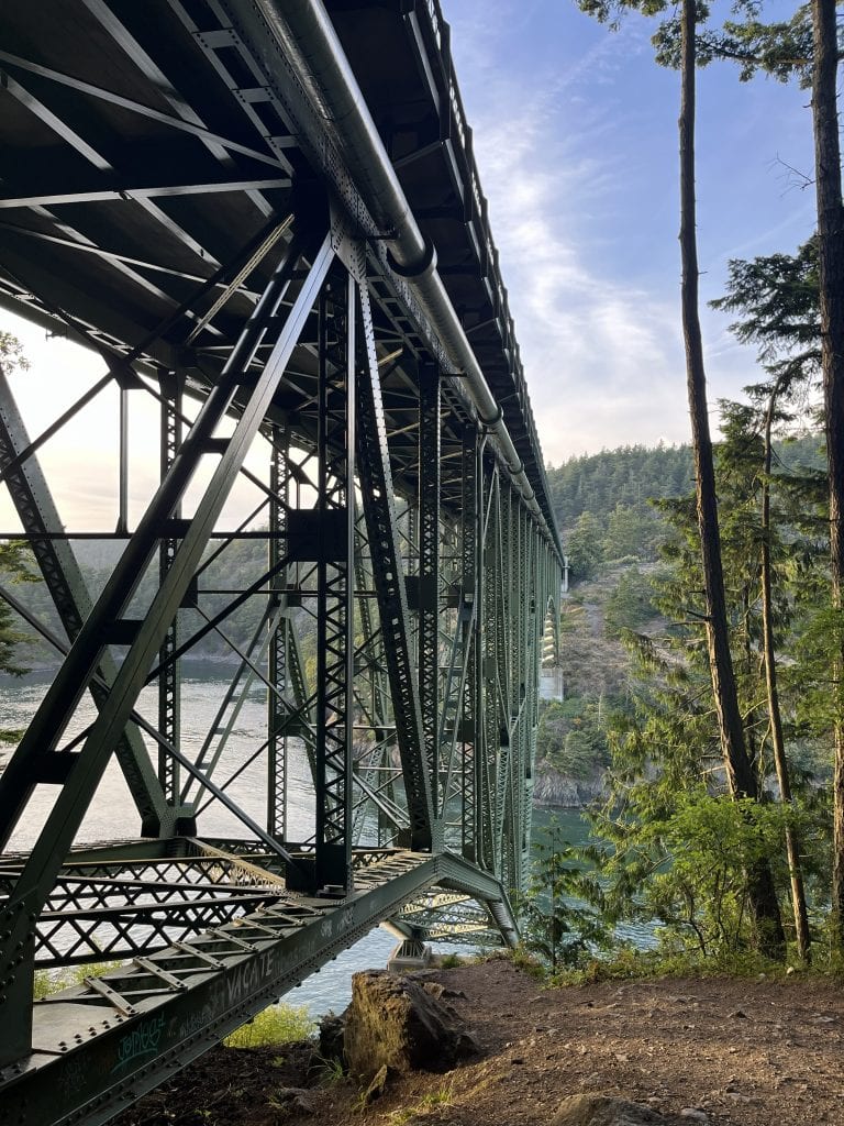 Steel truss bridge at Deception Pass State Park spanning between Fidalgo and Whidbey Islands, surrounded by forest and coastal cliffs.