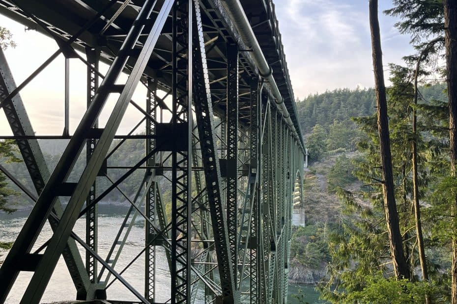 Steel truss bridge at Deception Pass State Park spanning between Fidalgo and Whidbey Islands, surrounded by forest and coastal cliffs.