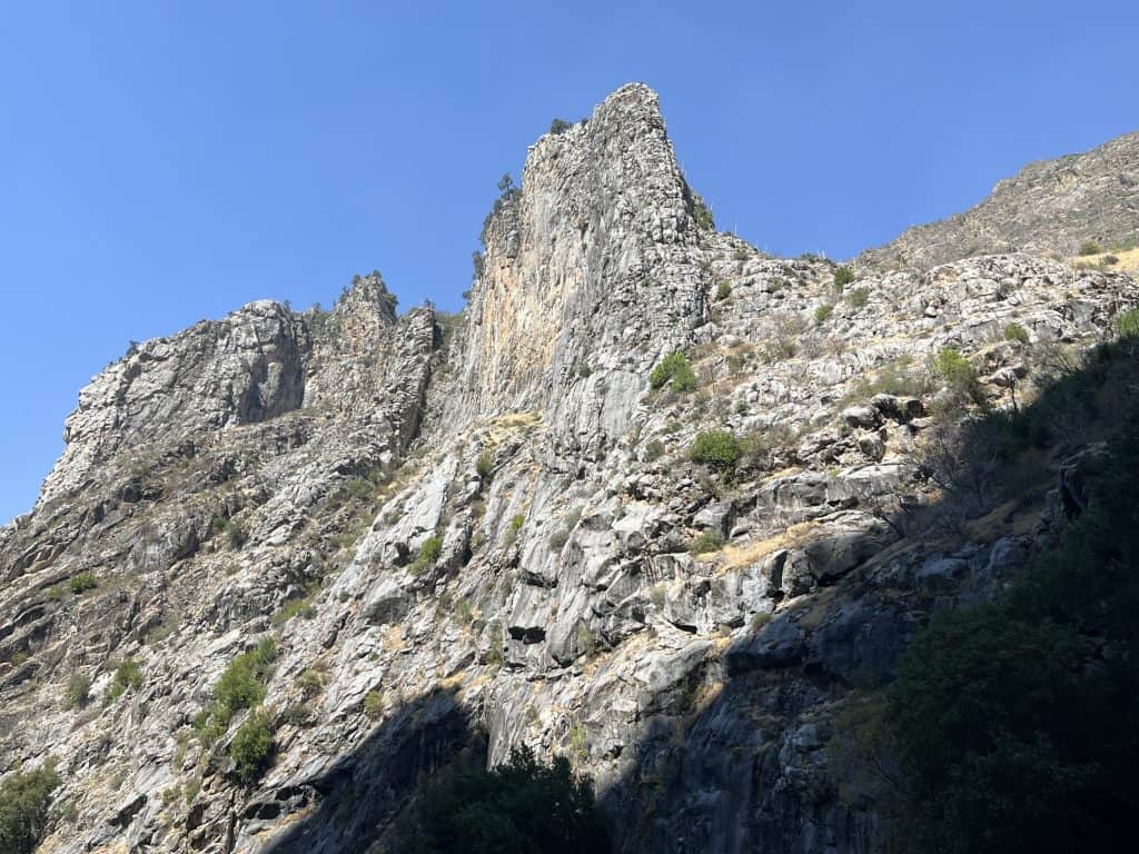 Steep granite canyon walls rising above Kings Canyon Scenic Byway in Kings Canyon National Park, California.